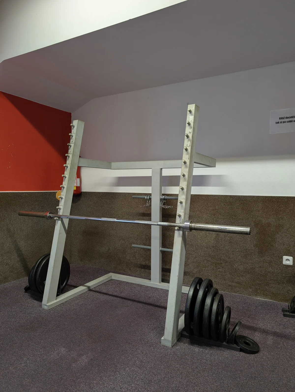 Stojan s velkou činkou pro dřepy a mrtvý tah
